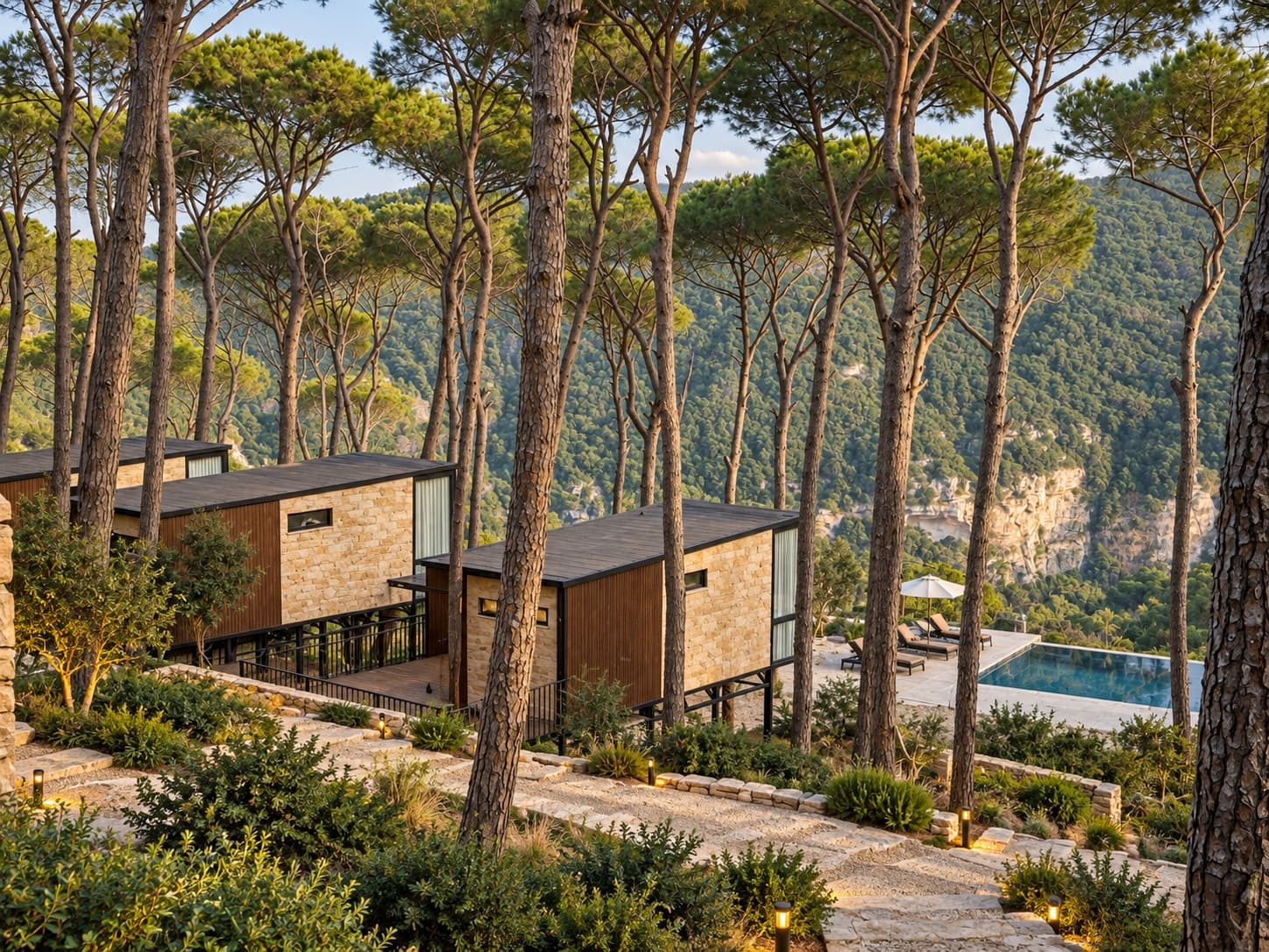 Bungalows stepping down the pine slope to the pool, with the valley beyond
